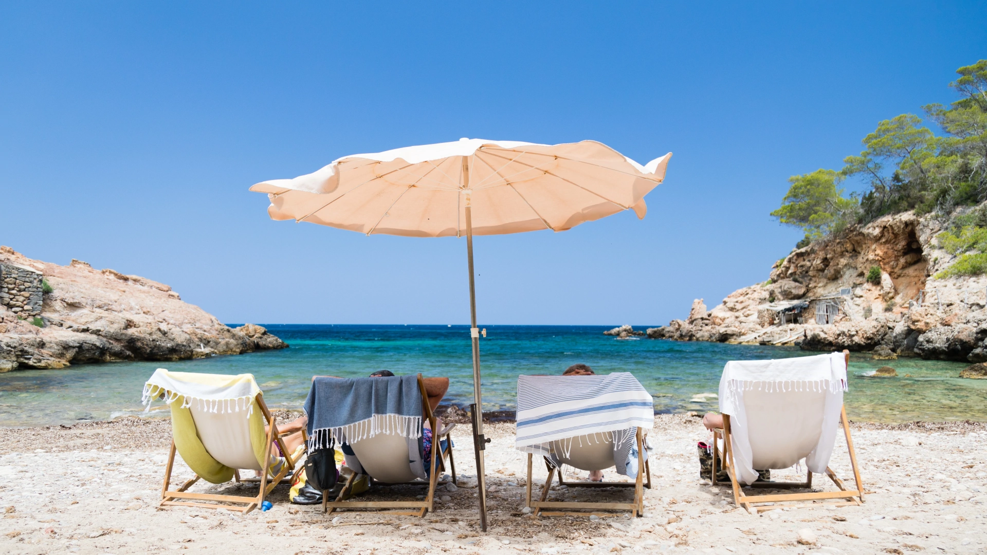 shot four people sunbeds beach 1